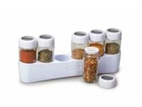 Joie cabinet spice rack. White rack with six transparent spice bottles in a spice holder against a white background